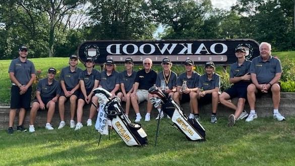 golfers and coaches sitting in front of Oakwood Country Club sign